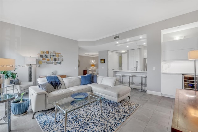 tiled living room with ornamental molding and sink