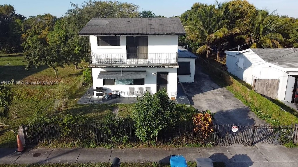 back of property with a balcony and a patio