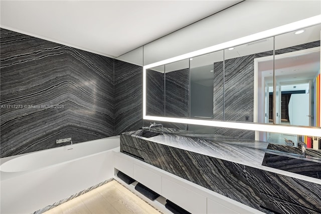 bathroom featuring a tub to relax in and vanity