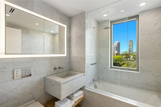 bathroom with tiled shower / bath and tile walls