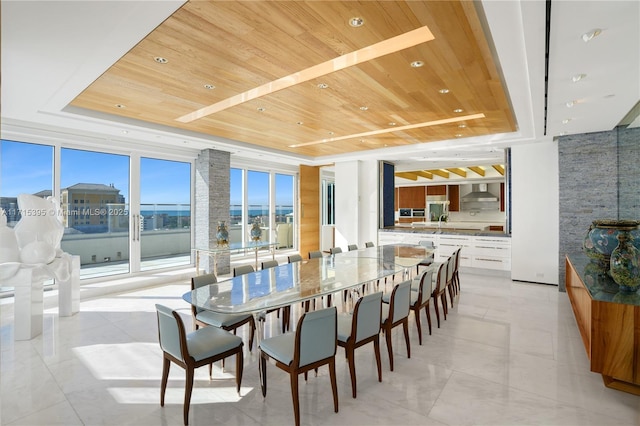 dining area featuring a tray ceiling, expansive windows, and wooden ceiling