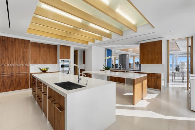 kitchen with light tile patterned floors, a large island, and sink