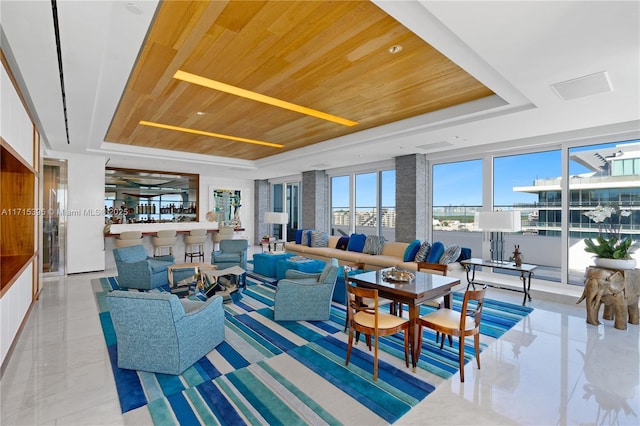 tiled living room featuring a raised ceiling and wood ceiling