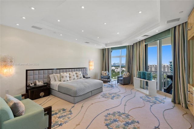 carpeted bedroom featuring a raised ceiling and access to exterior