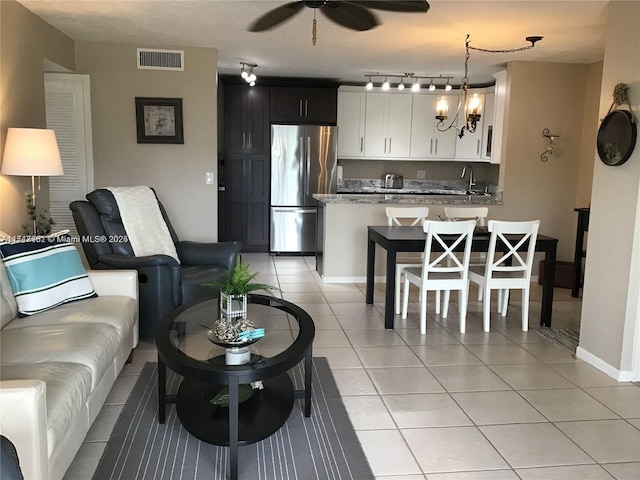 tiled living room featuring ceiling fan and sink