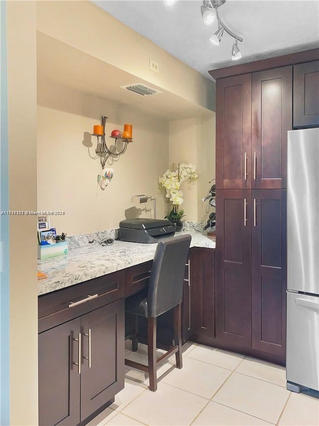 1013 Green Pine Blvd Unit C2, West Palm Beach, FL 33409 - kitchen with freestanding refrigerator, light tile patterned flooring, light stone counters, and a desk