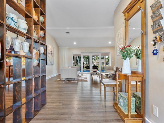 living area featuring french doors, hardwood / wood-style floors, and lofted ceiling