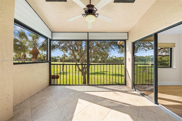 unfurnished sunroom with ceiling fan