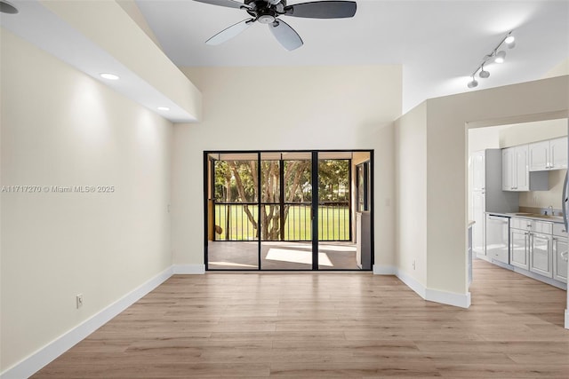 empty room with ceiling fan and light hardwood / wood-style flooring