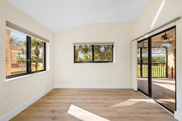 unfurnished room with ceiling fan, light hardwood / wood-style flooring, and lofted ceiling