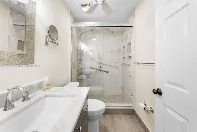 bathroom with walk in shower, hardwood / wood-style flooring, vanity, and toilet