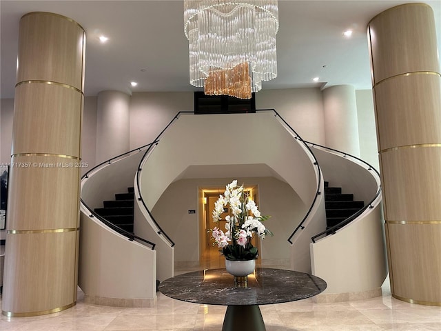 stairs with recessed lighting, a notable chandelier, and a high ceiling