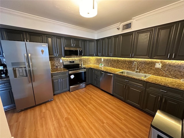 kitchen with visible vents, stainless steel appliances, a sink, and ornamental molding