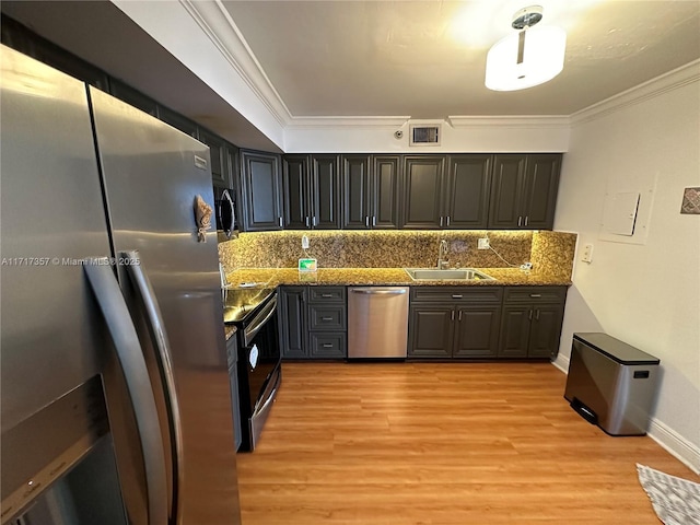 kitchen with stainless steel appliances, ornamental molding, a sink, and visible vents