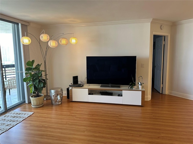 living room featuring ornamental molding, plenty of natural light, and wood finished floors