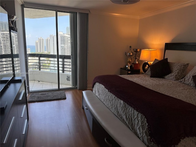 bedroom featuring dark wood-type flooring, access to exterior, a view of city, a wall of windows, and crown molding