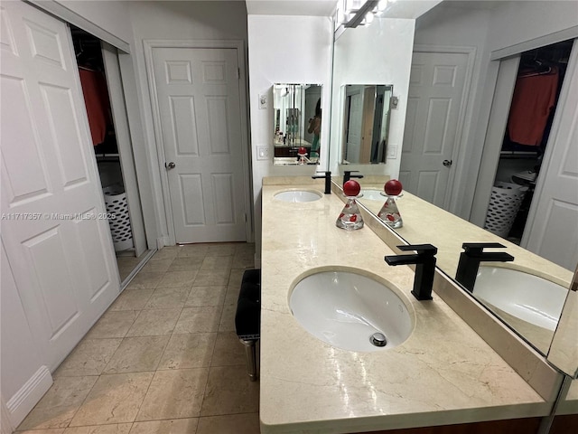 bathroom featuring double vanity, a sink, and tile patterned floors