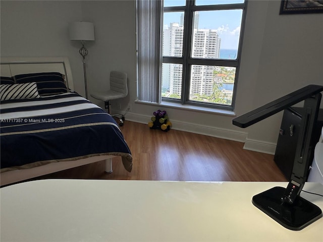 bedroom featuring wood finished floors and baseboards