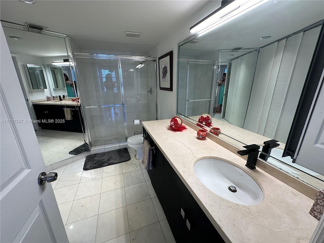 bathroom featuring toilet, a stall shower, vanity, and visible vents