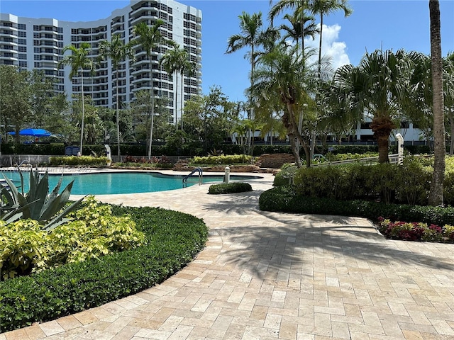 community pool with a patio and fence