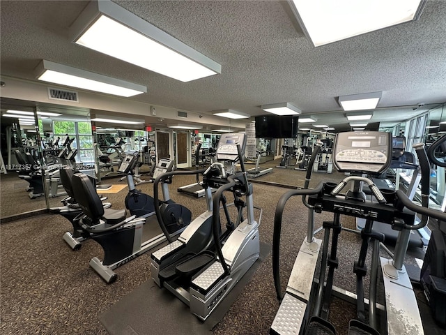 exercise room with visible vents and a textured ceiling