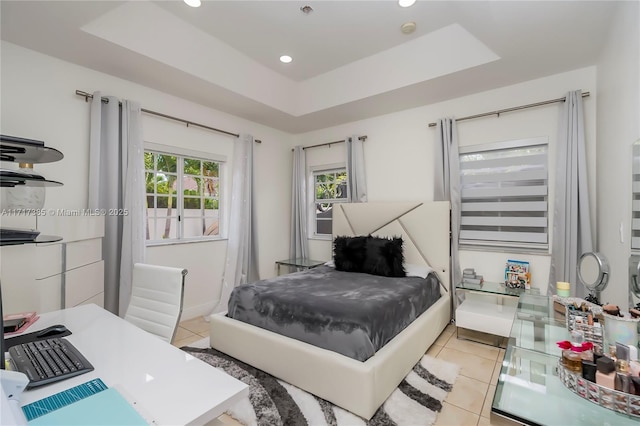 bedroom featuring light tile patterned floors and a tray ceiling