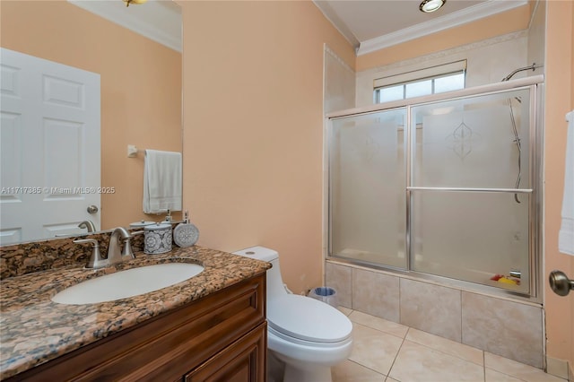 full bathroom featuring combined bath / shower with glass door, vanity, toilet, crown molding, and tile patterned floors