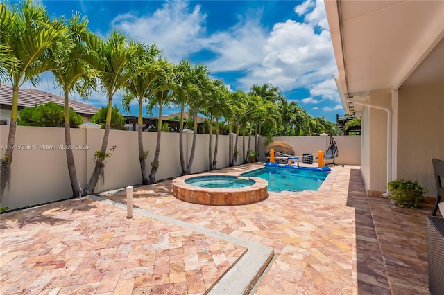 view of pool with a patio area and an in ground hot tub