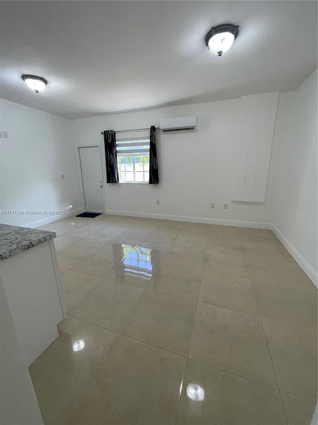 spare room with light tile patterned floors and a wall unit AC