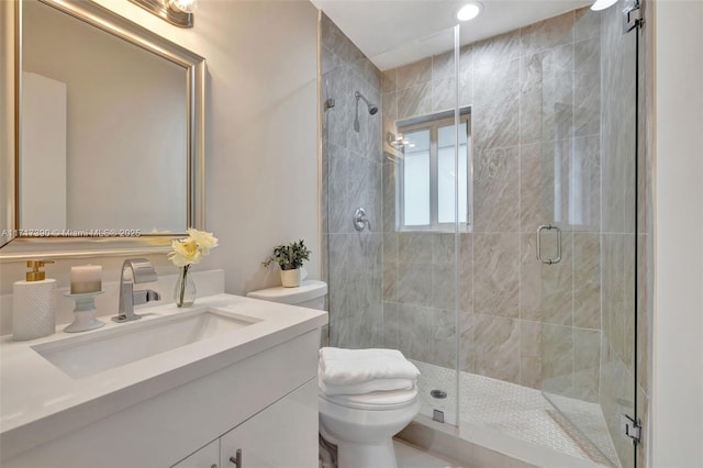 bathroom featuring vanity, toilet, and a shower with door