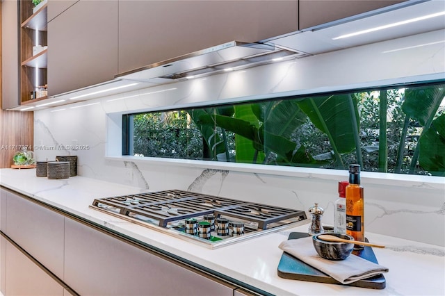 kitchen with light stone counters and stainless steel gas stovetop