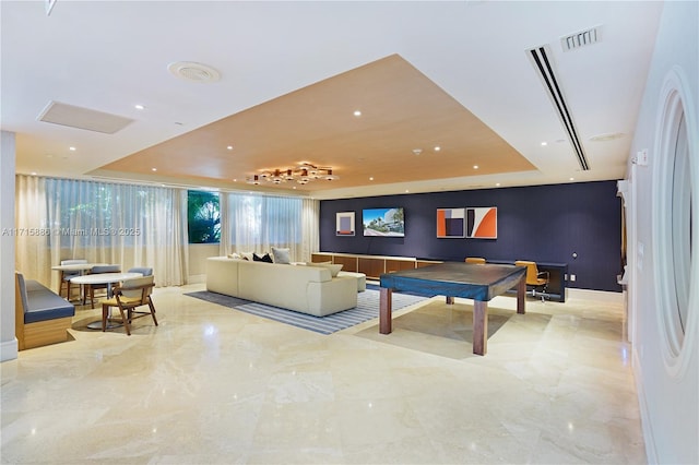 recreation room with a raised ceiling