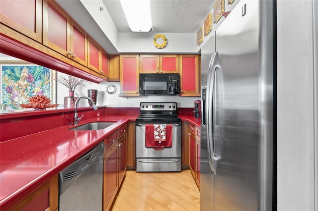 kitchen with black appliances, light hardwood / wood-style floors, and sink