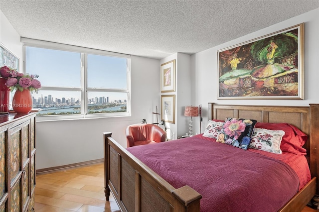 bedroom with a textured ceiling and light hardwood / wood-style flooring