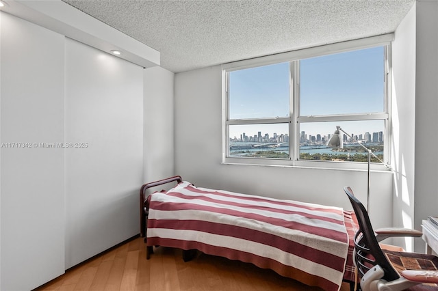 bedroom with a textured ceiling and hardwood / wood-style flooring