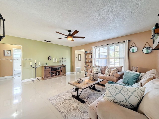 tiled living room featuring ceiling fan and a textured ceiling