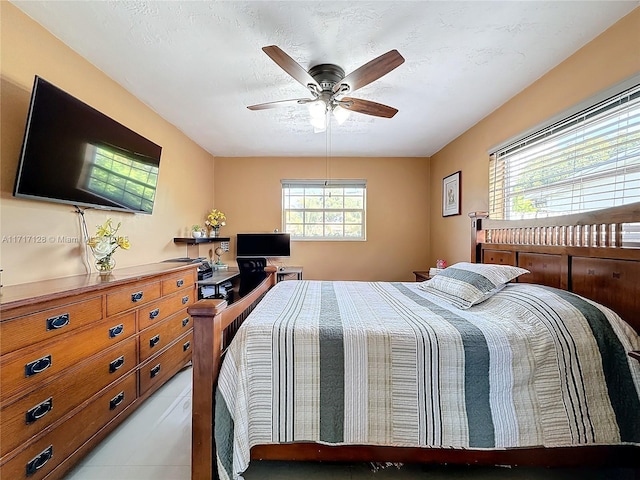 bedroom featuring ceiling fan and a textured ceiling