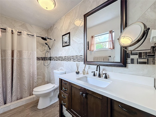 bathroom with toilet, vanity, tile walls, and walk in shower