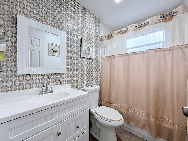 full bathroom with vanity, shower / tub combo, and toilet