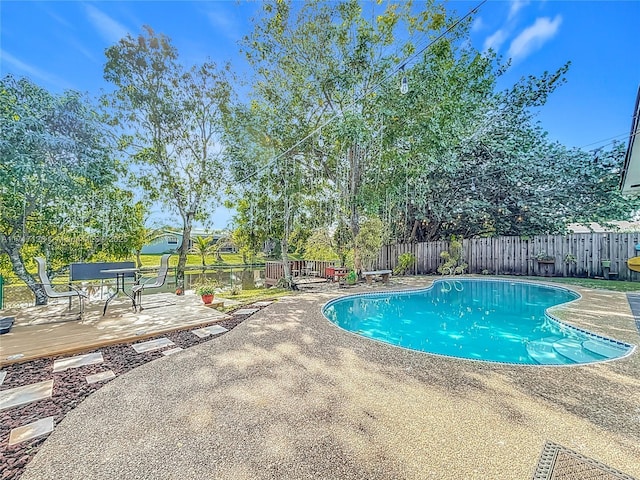 view of swimming pool with a patio and a wooden deck