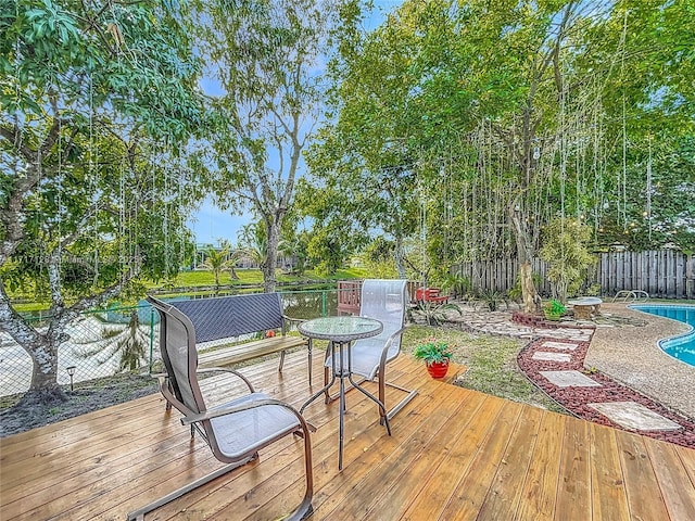 wooden deck with a fenced in pool