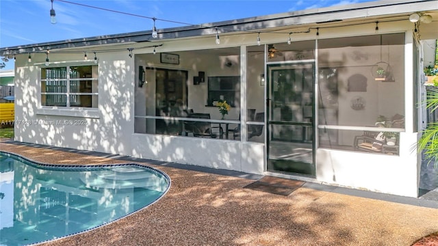 back of property with a sunroom