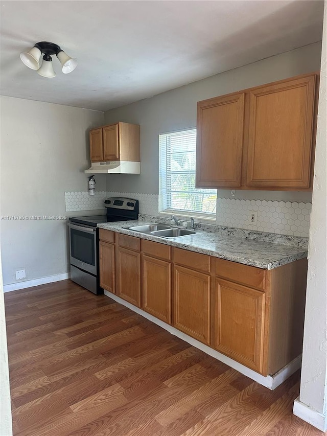 kitchen featuring stainless steel electric range, dark hardwood / wood-style floors, decorative backsplash, and sink