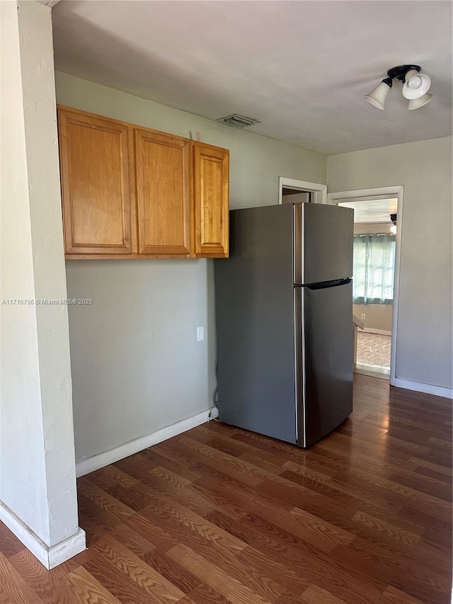 kitchen with stainless steel fridge and dark hardwood / wood-style flooring