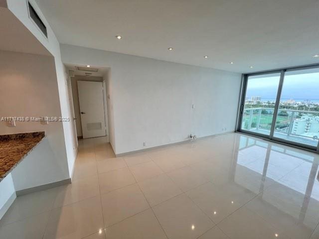 tiled spare room featuring expansive windows