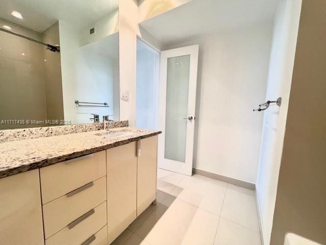 bathroom featuring walk in shower, tile patterned floors, and vanity