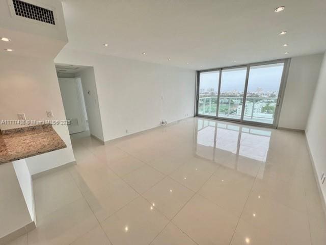 tiled empty room featuring expansive windows