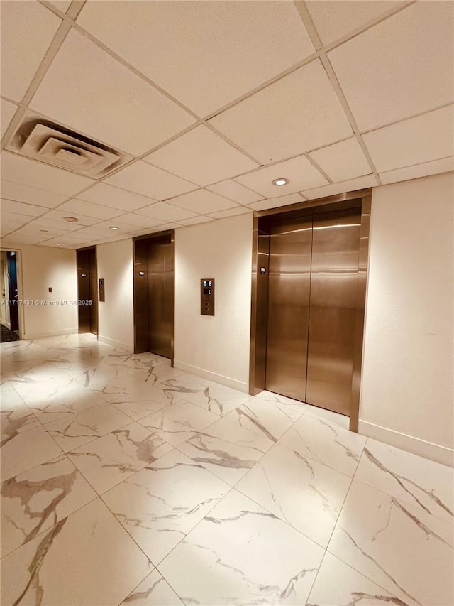 interior space featuring elevator and a drop ceiling