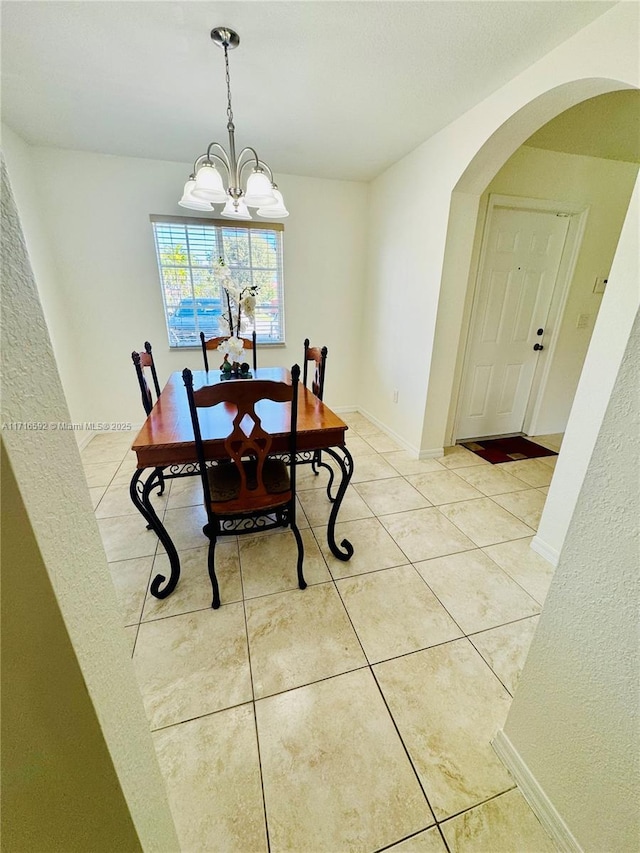 dining room with tile patterned floors and a chandelier