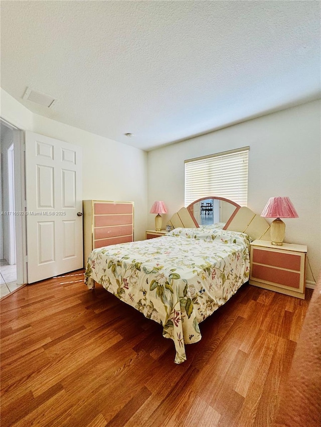 bedroom featuring hardwood / wood-style floors and a textured ceiling